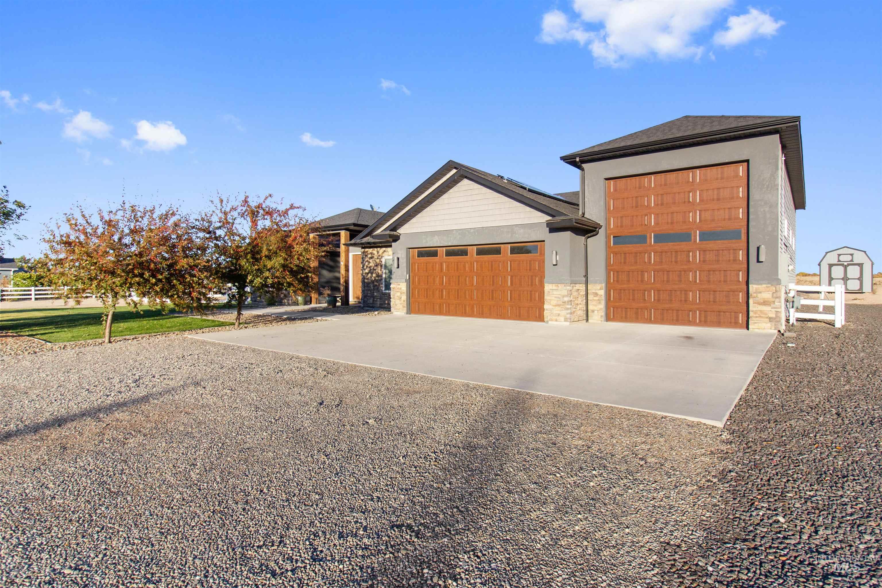 View of front of house with concrete driveway, a garage, and stone siding