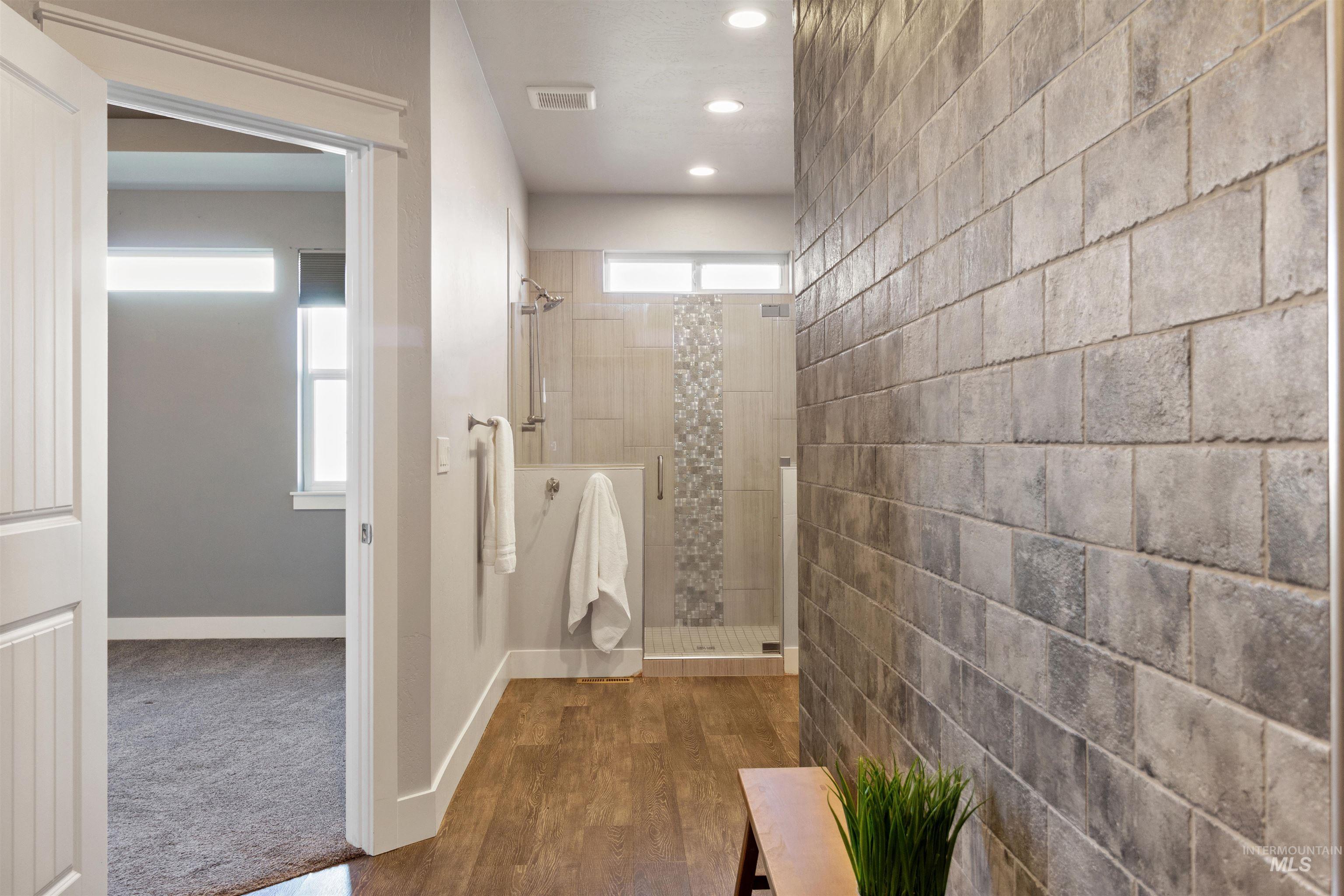 Bathroom with a shower stall, dark wood-type flooring, and recessed lighting