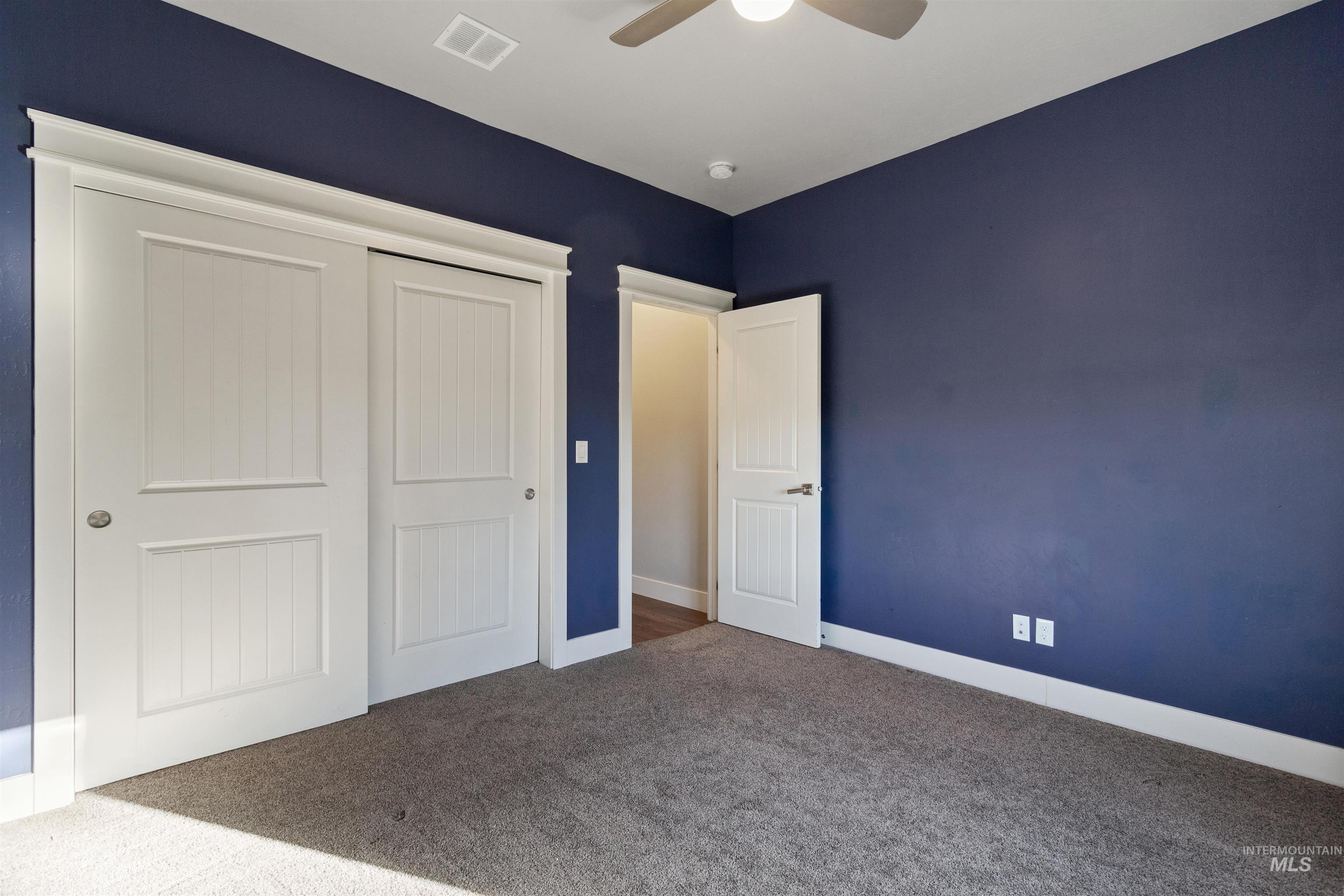 Unfurnished bedroom with a closet, carpet, and ceiling fan