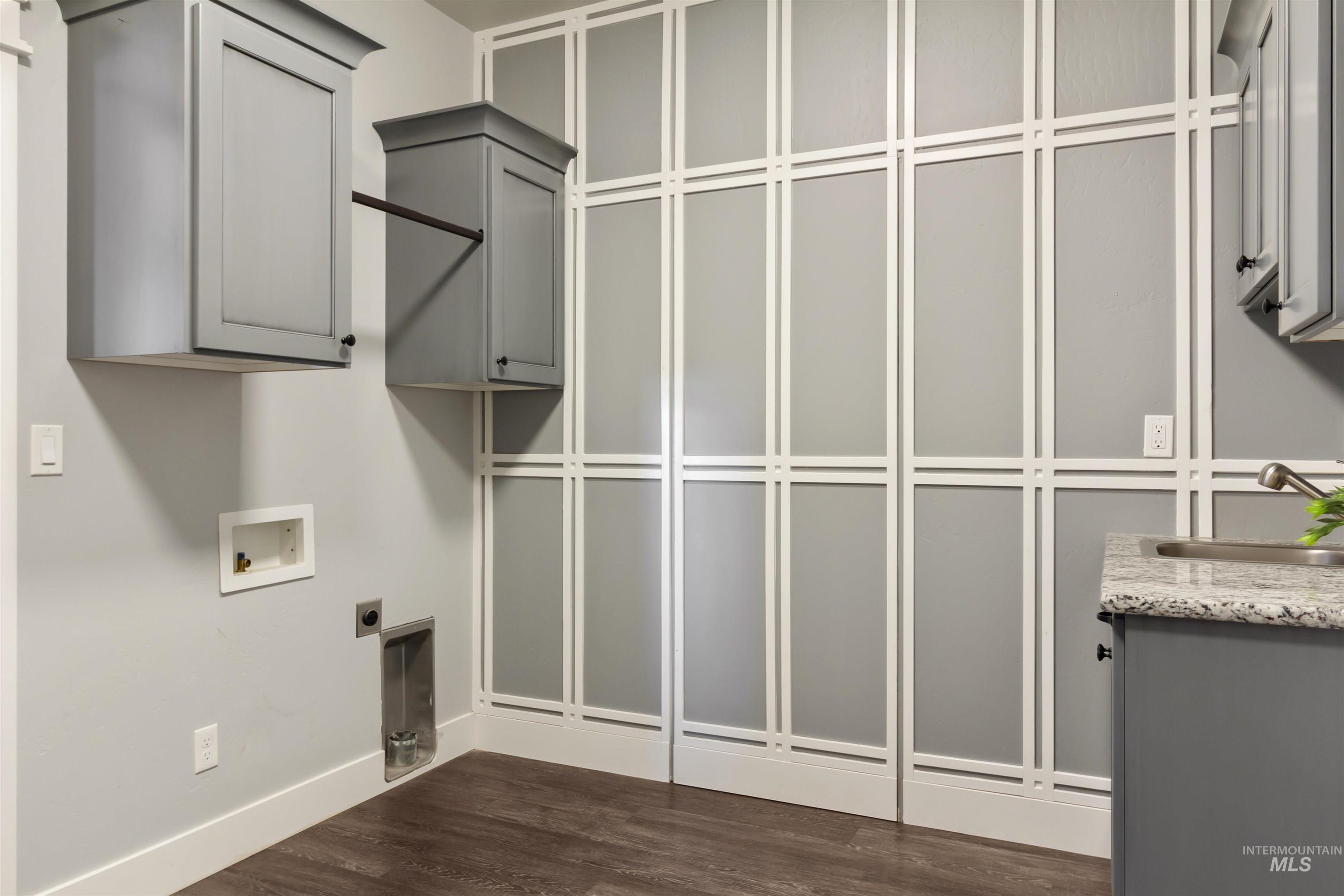 Laundry area with cabinet space, dark wood-style flooring, hookup for an electric dryer, and washer hookup
