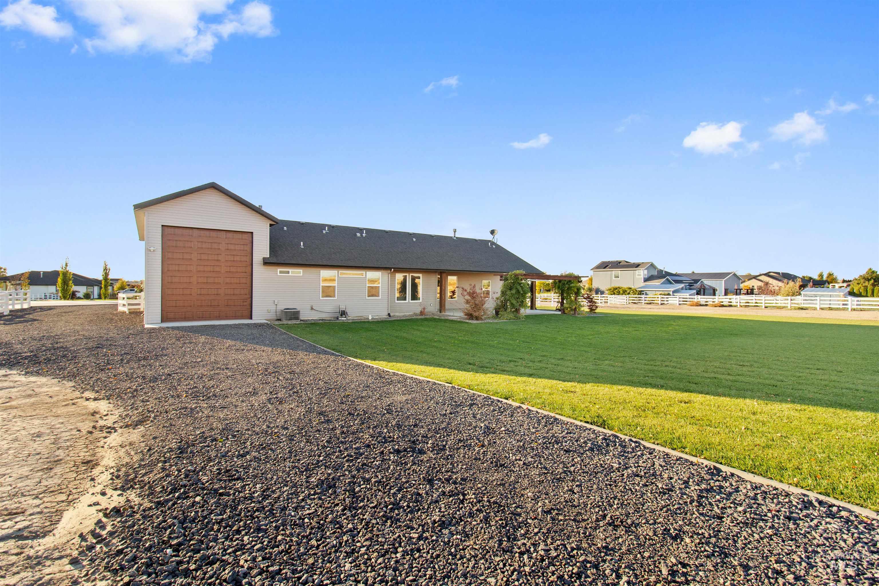 Ranch-style house featuring driveway, an attached garage, and a patio area