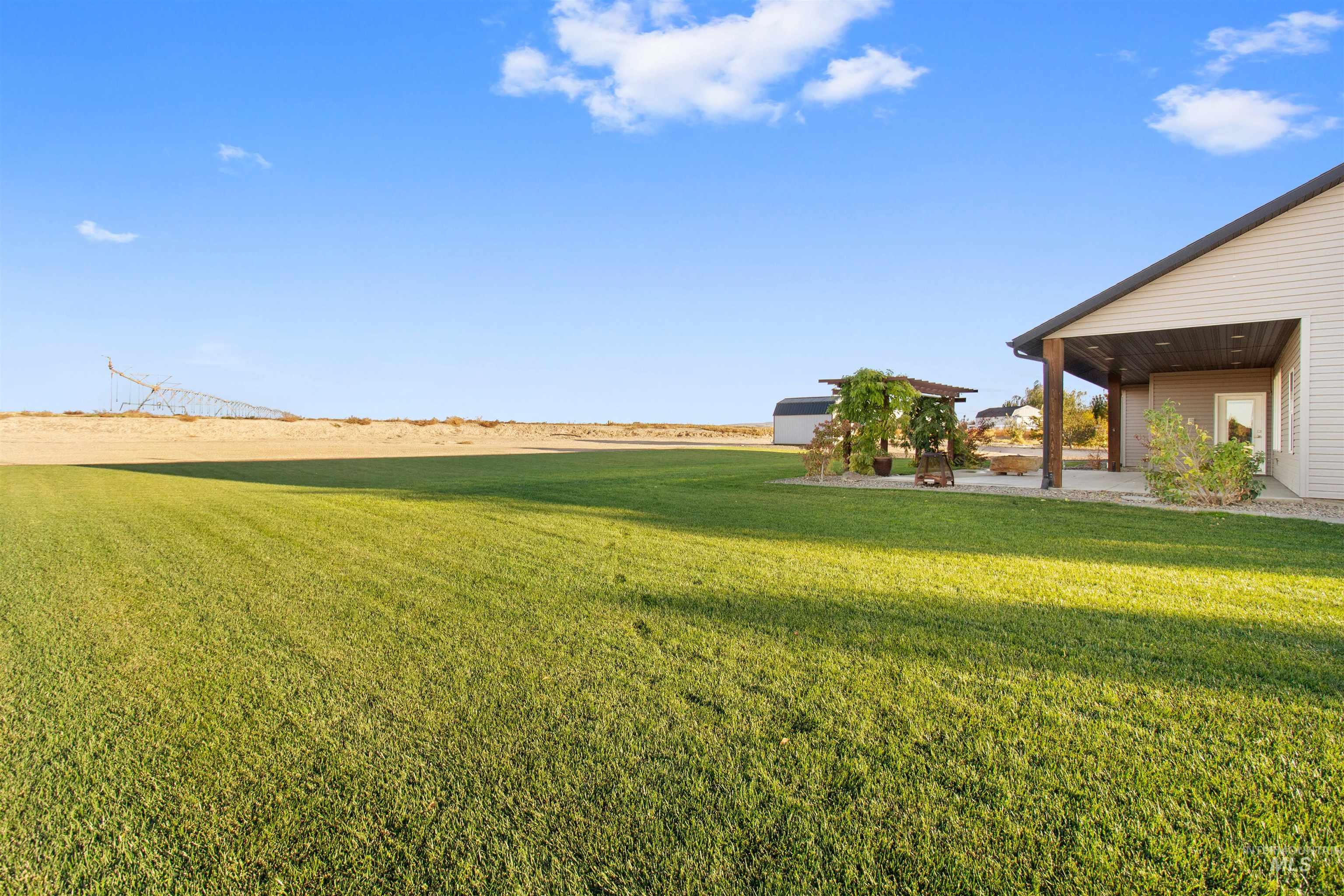 View of grassy yard with a patio area
