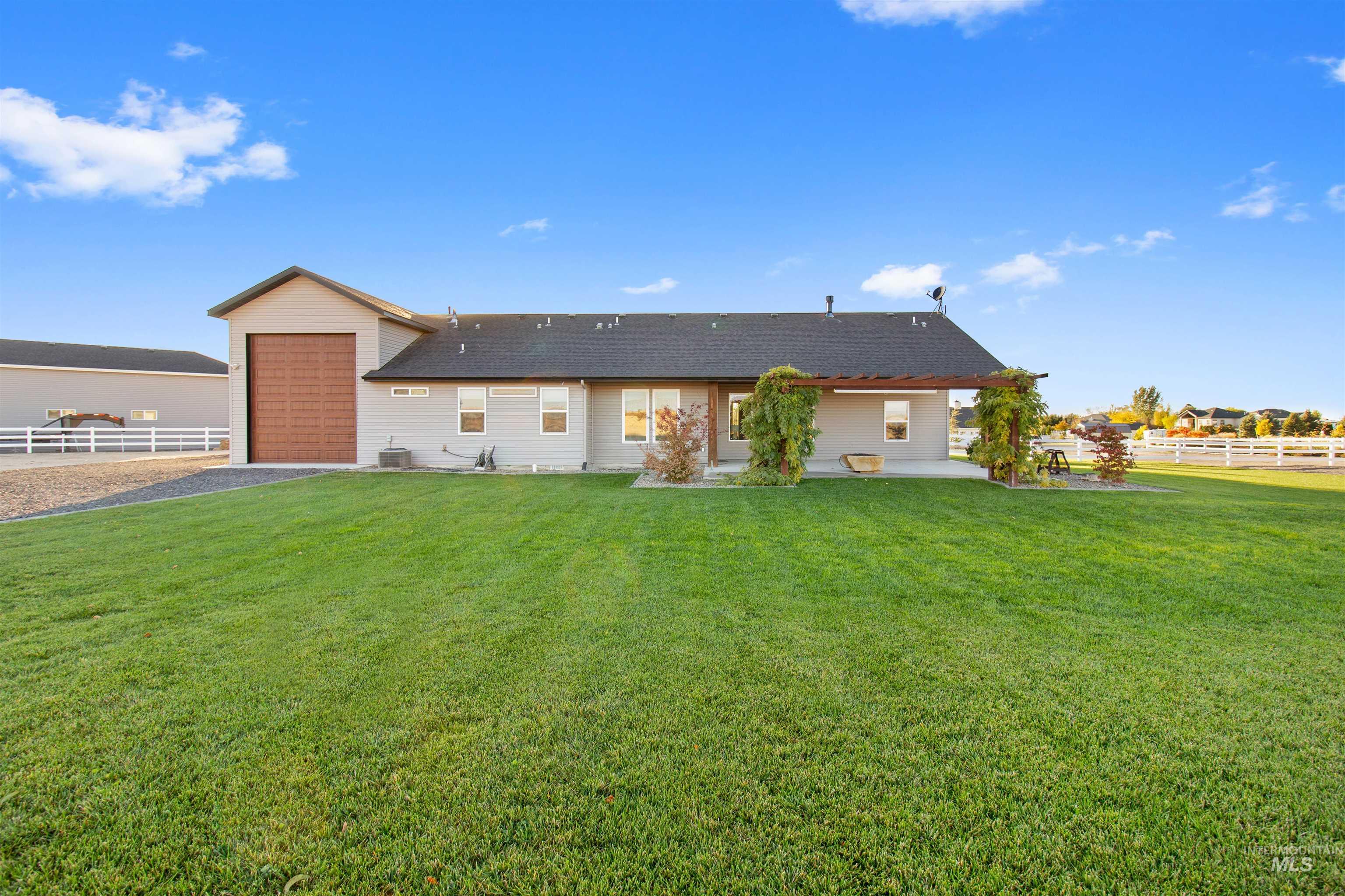 Rear view of house featuring a patio, an attached garage, and driveway