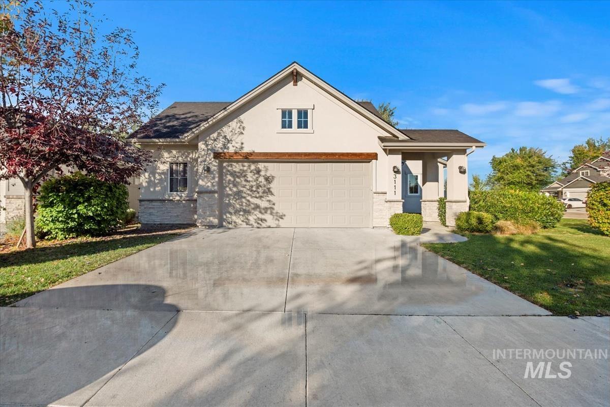 View of front of house with driveway, a front yard, and stucco siding