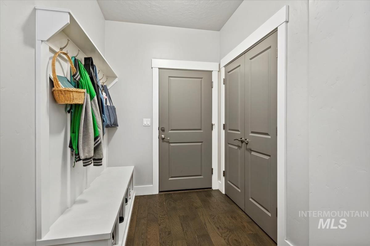 Mudroom featuring dark wood-style floors and baseboards