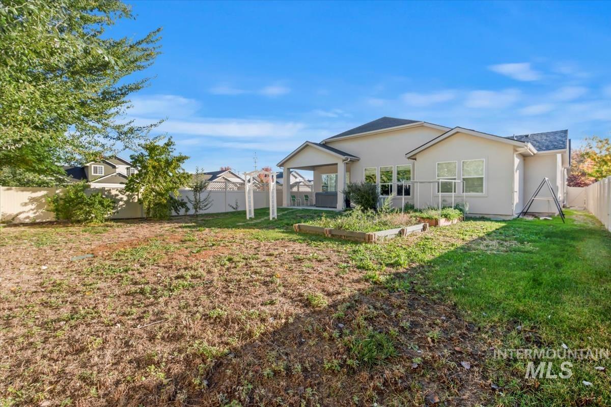 Back of property with a fenced backyard and stucco siding
