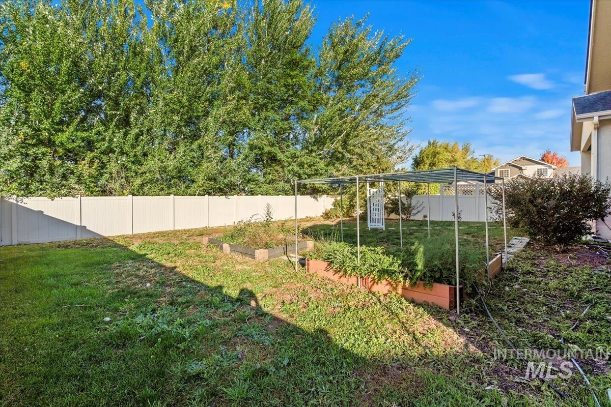 Fenced backyard featuring a vegetable garden