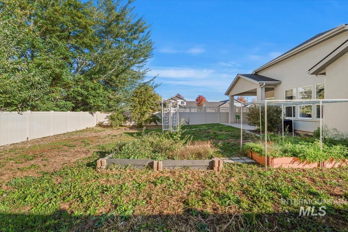 Fenced backyard with a vegetable garden