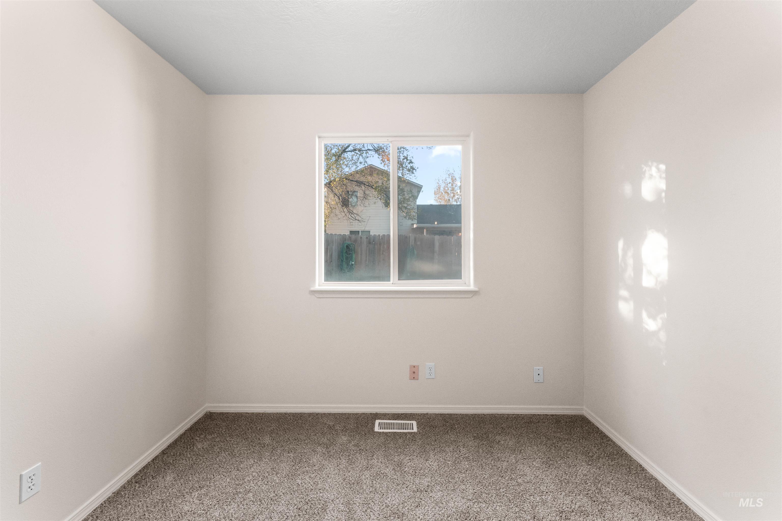 Empty room featuring carpet flooring and baseboards
