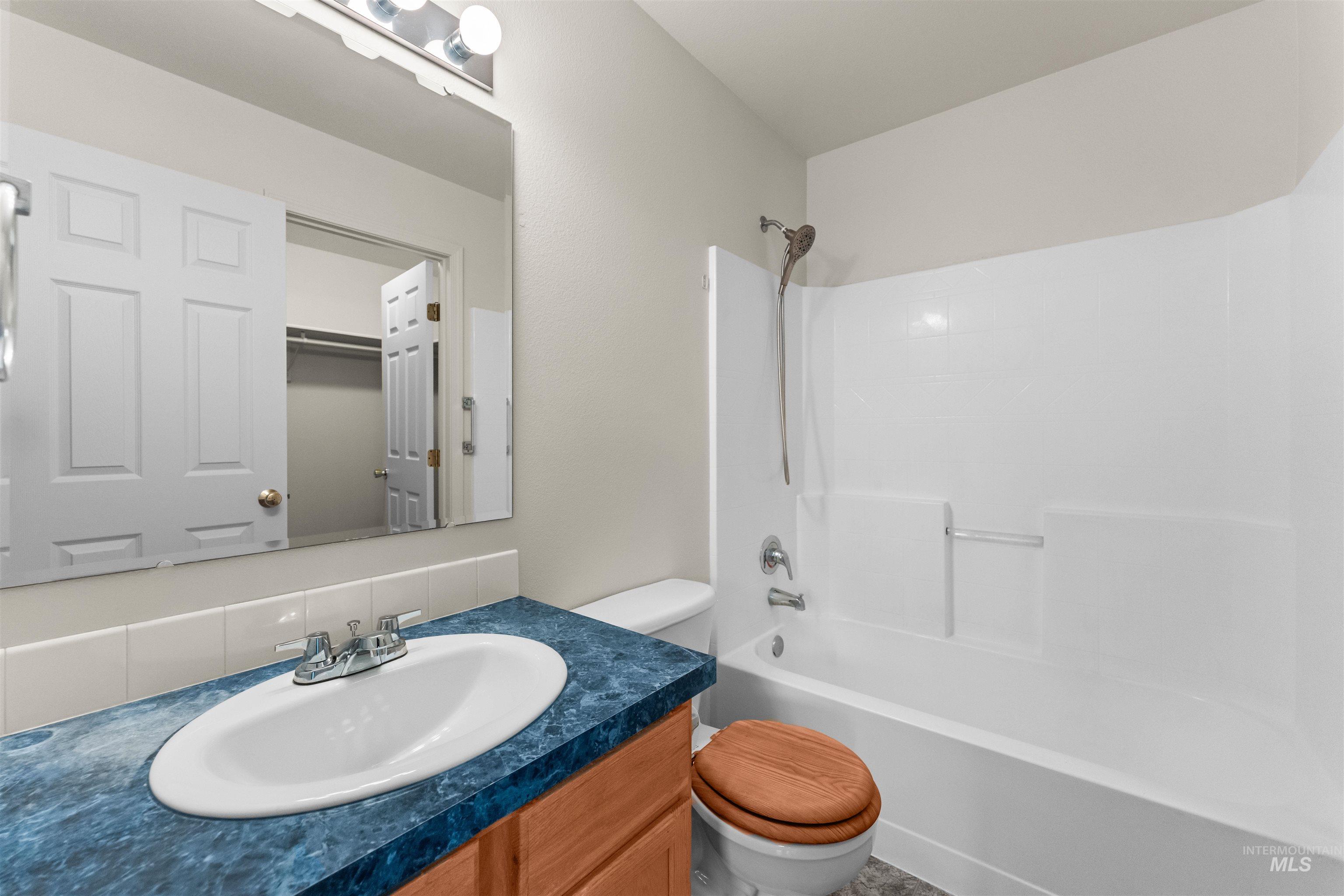 Bathroom featuring vanity and washtub / shower combination