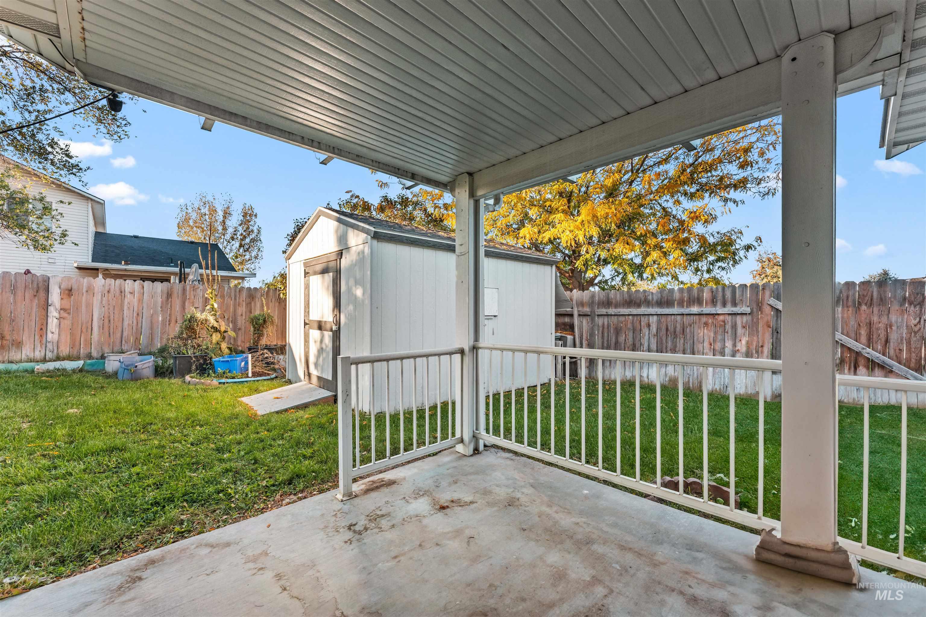 Fenced backyard with a patio area and a shed