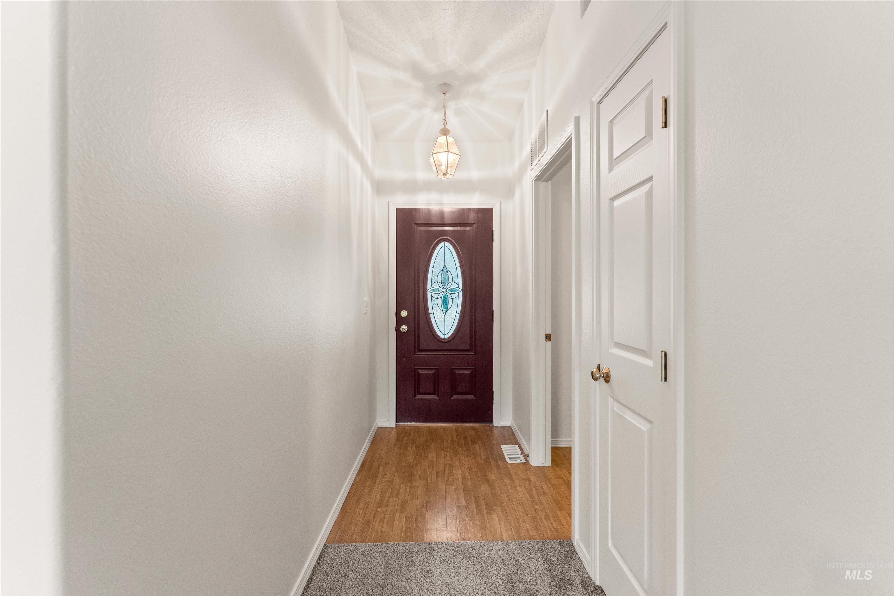 Doorway to outside with baseboards and wood finished floors