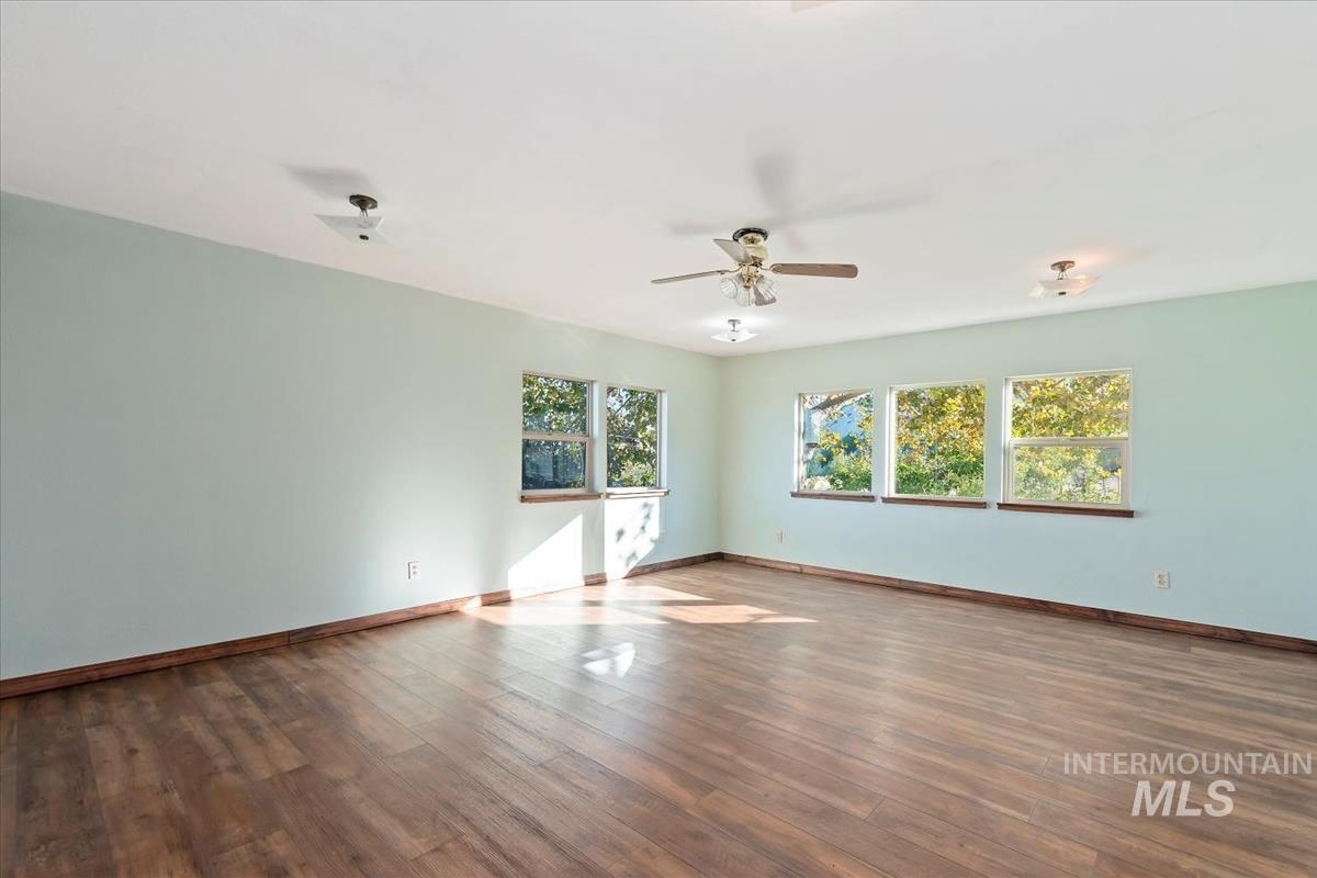 Unfurnished room featuring dark wood finished floors and ceiling fan