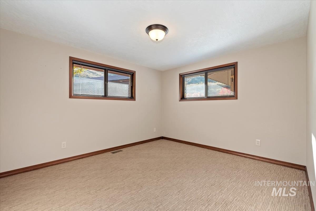 Carpeted empty room featuring plenty of natural light