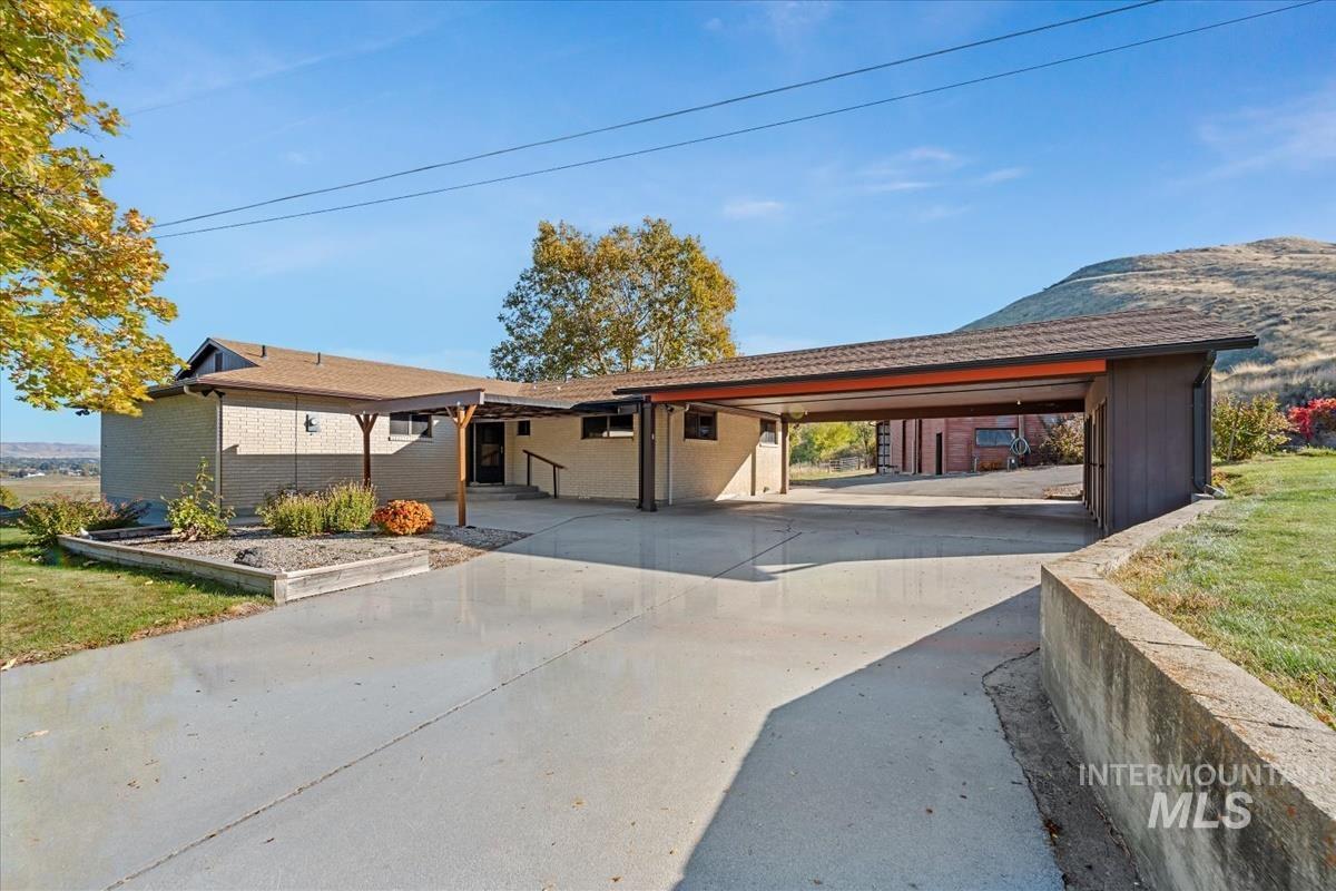 View of front of home with concrete driveway, brick siding, and a carport