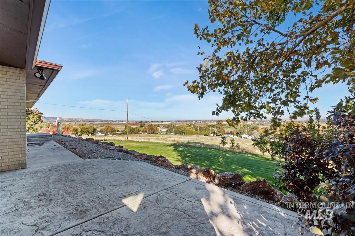 View of grassy yard with a patio area