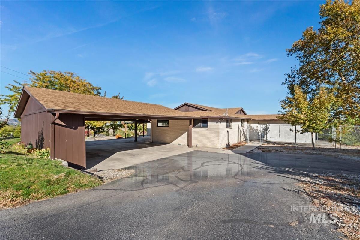 Single story home with a shingled roof, brick siding, and driveway