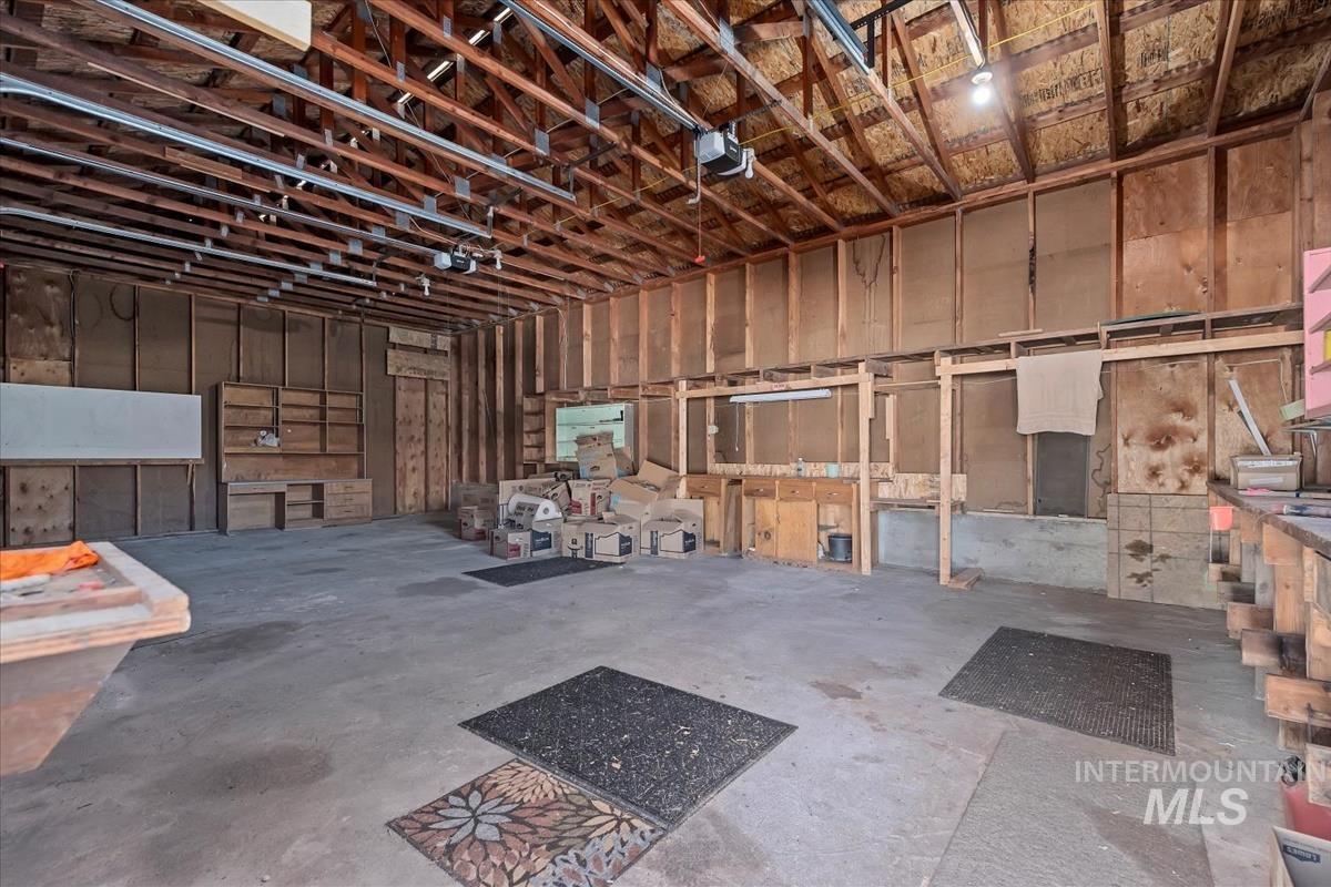 Miscellaneous room with unfinished concrete flooring and a garage