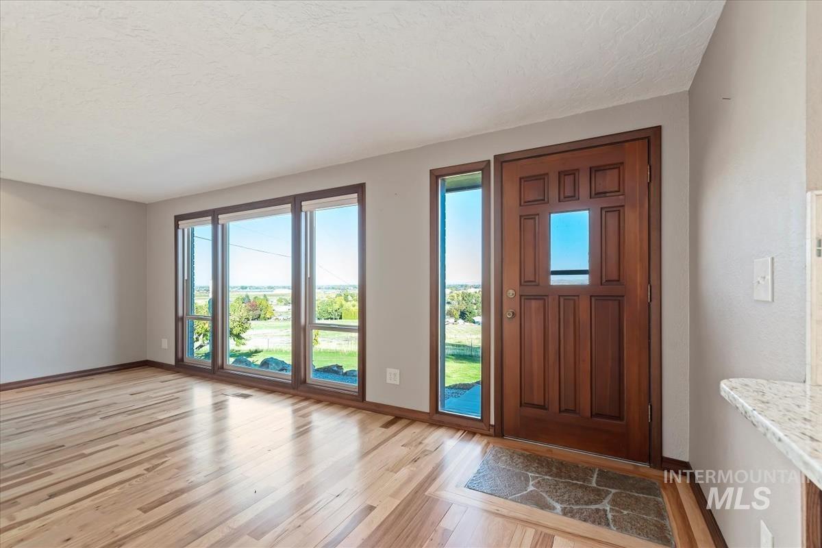 Foyer entrance featuring light wood-type flooring and a textured ceiling