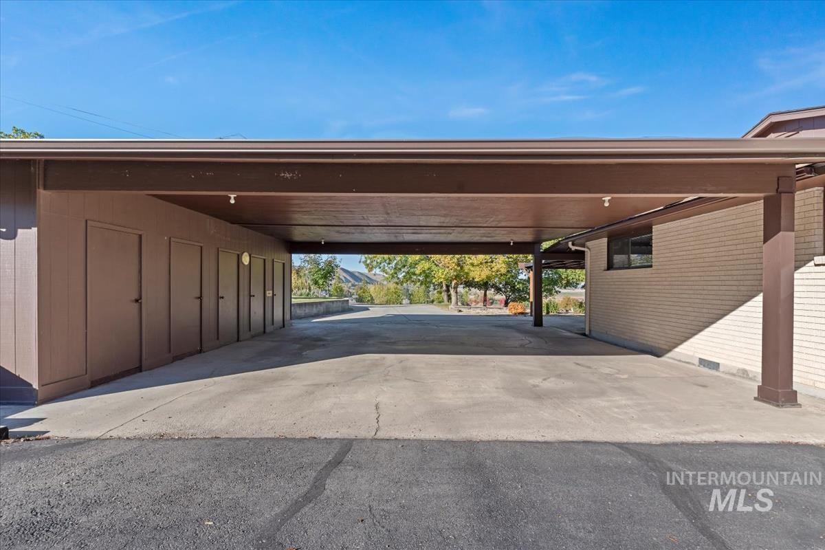 View of vehicle parking with a carport and asphalt driveway