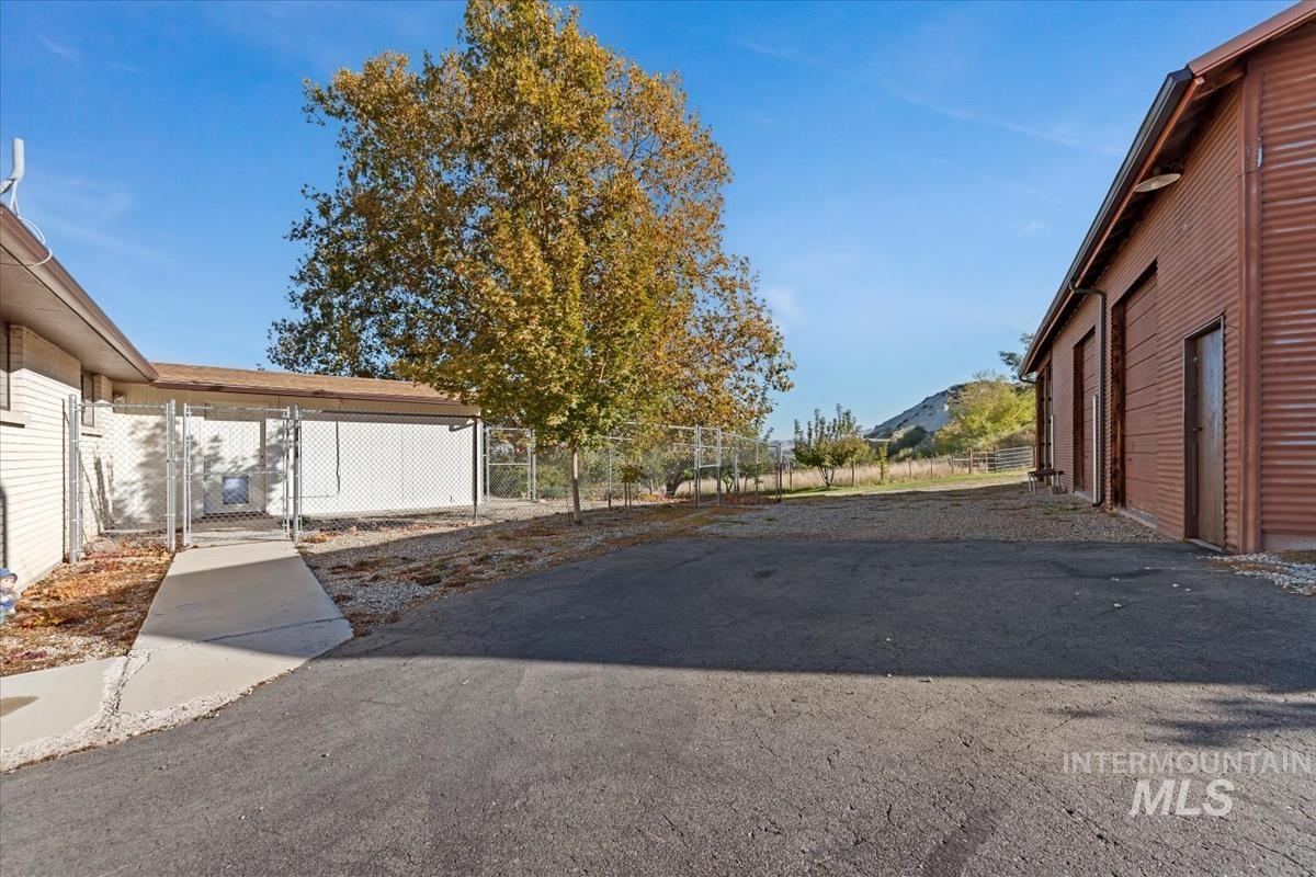 View of asphalt driveway featuring a gate
