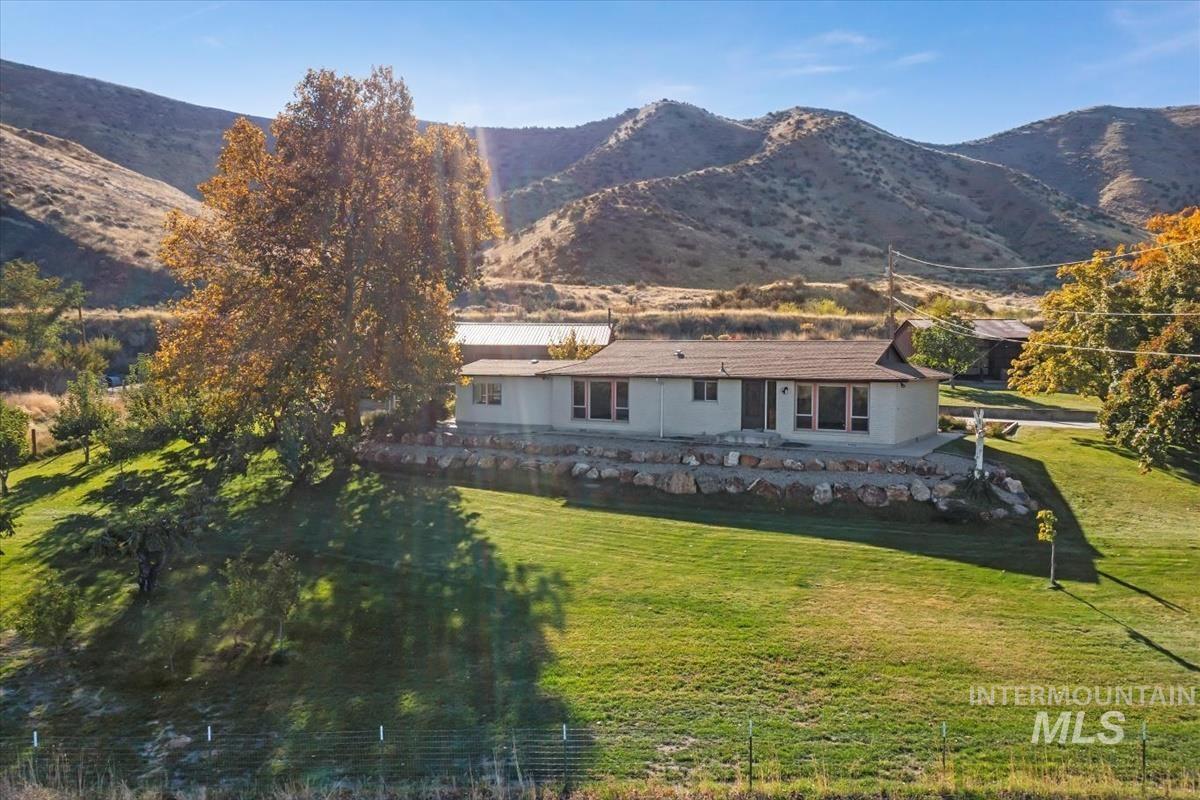 Back of house featuring a lawn and a mountain view