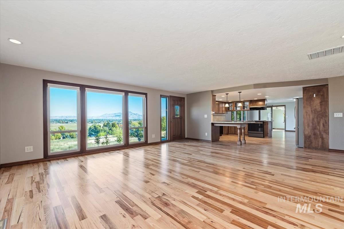 Unfurnished living room featuring light wood-style floors, recessed lighting, and a mountain view