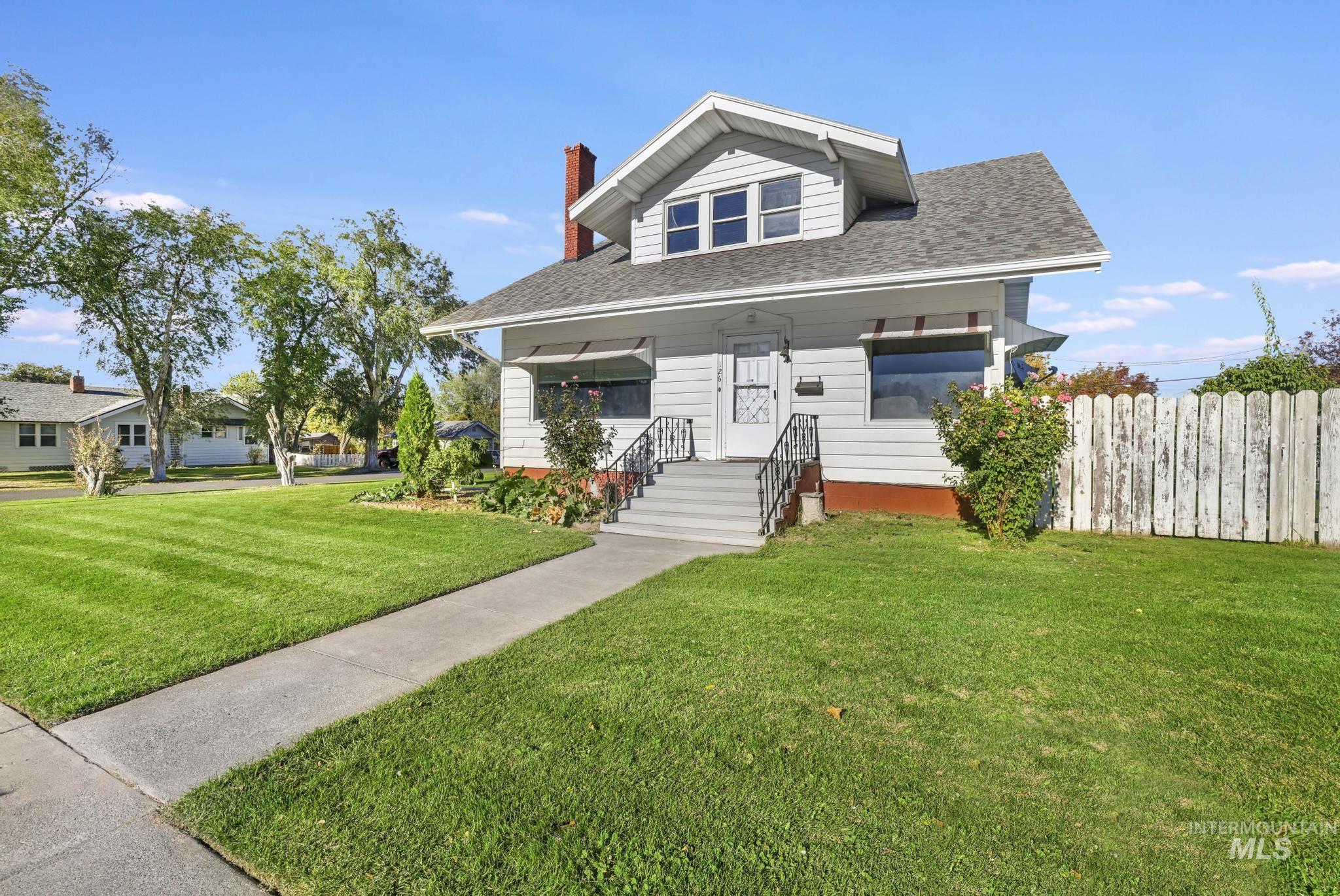 Bungalow with a chimney, a porch, and roof with shingles