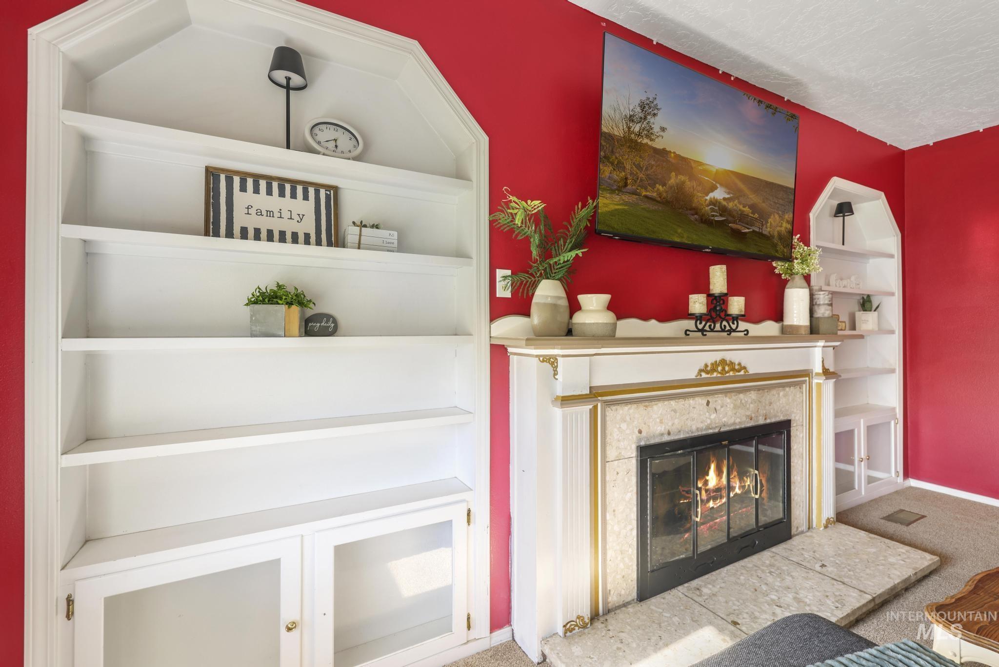 Detailed view of carpet floors, a fireplace, and built in shelves