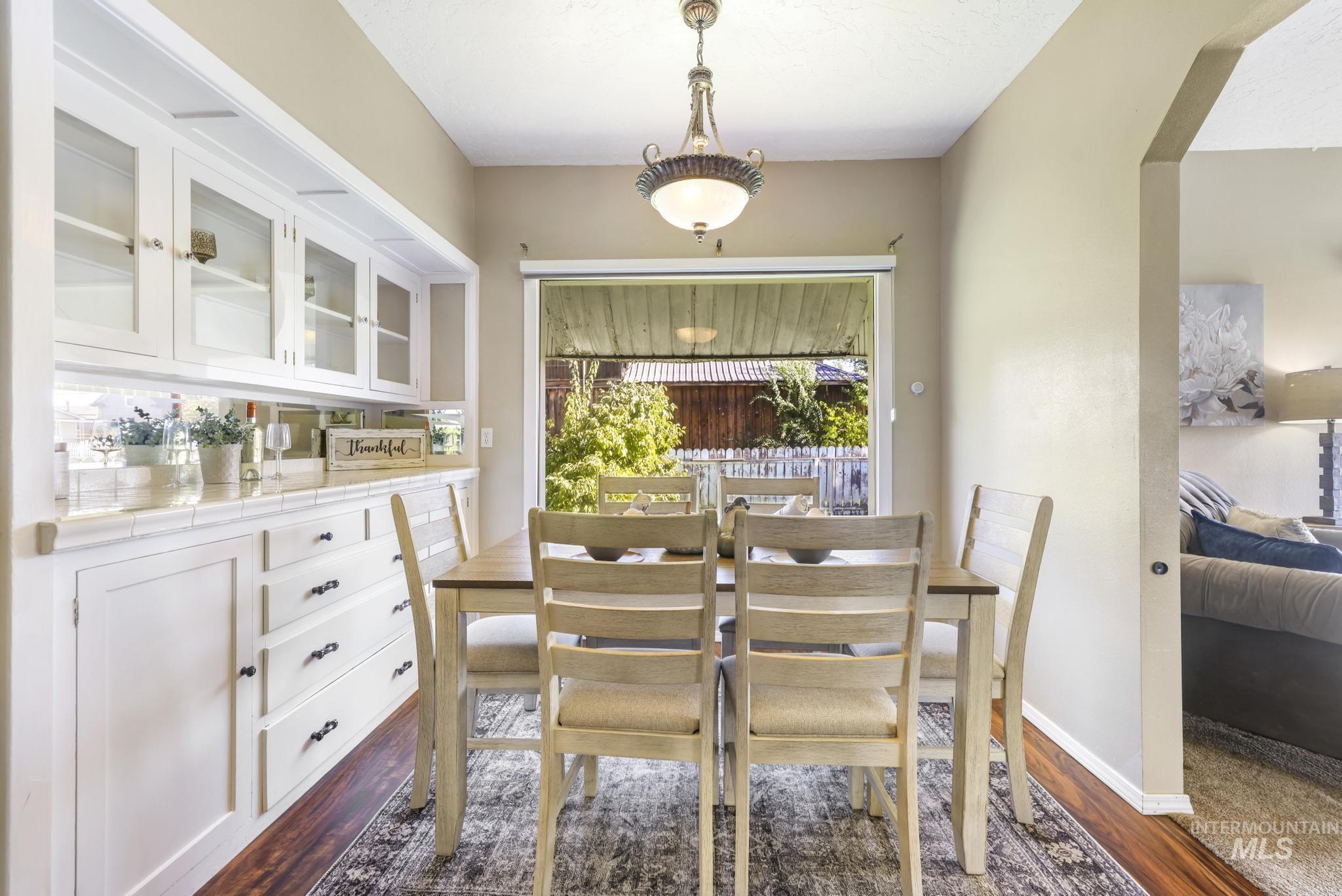 Dining space featuring dark wood-style flooring and arched walkways
