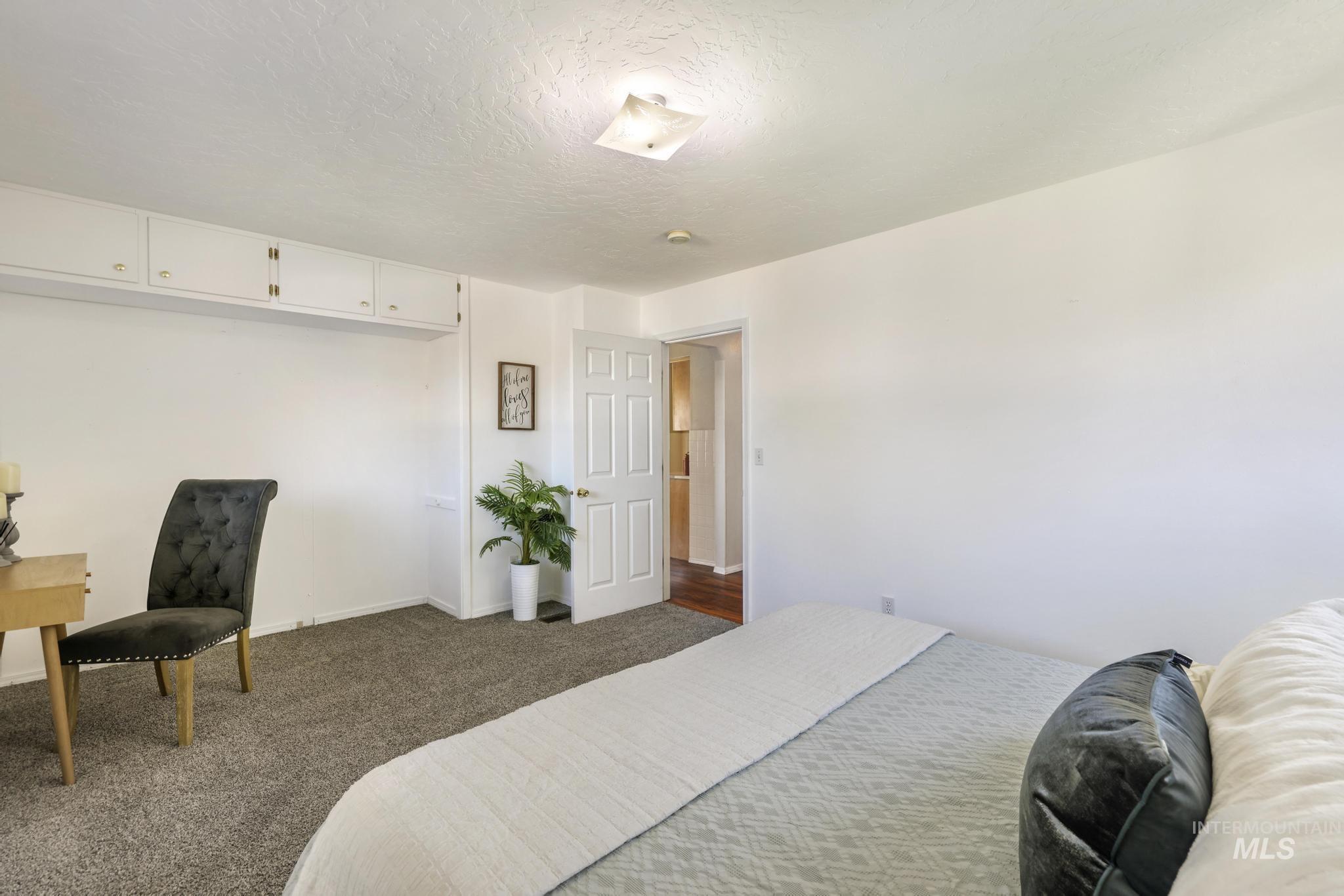 Bedroom with carpet floors, a textured ceiling, and a closet