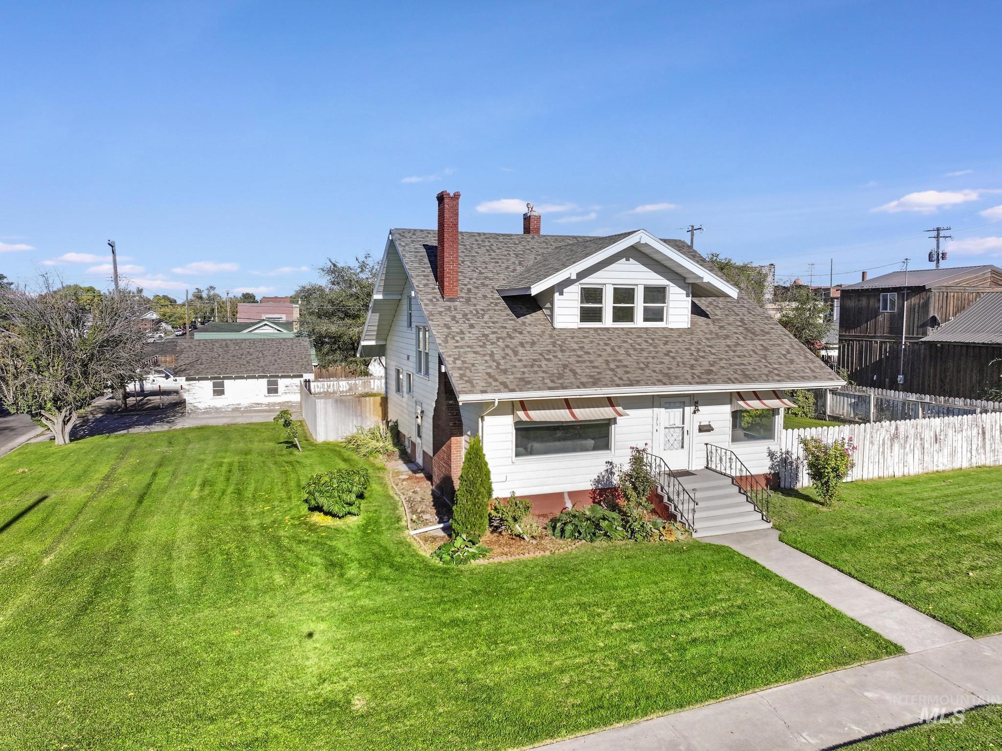 Bungalow featuring a chimney and roof with shingles