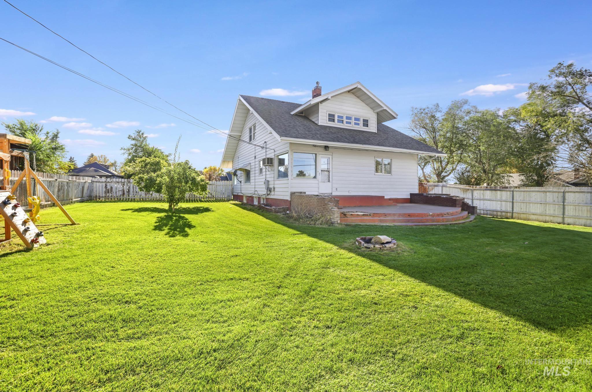 Back of house featuring a fenced backyard, a chimney, a playground, and a deck