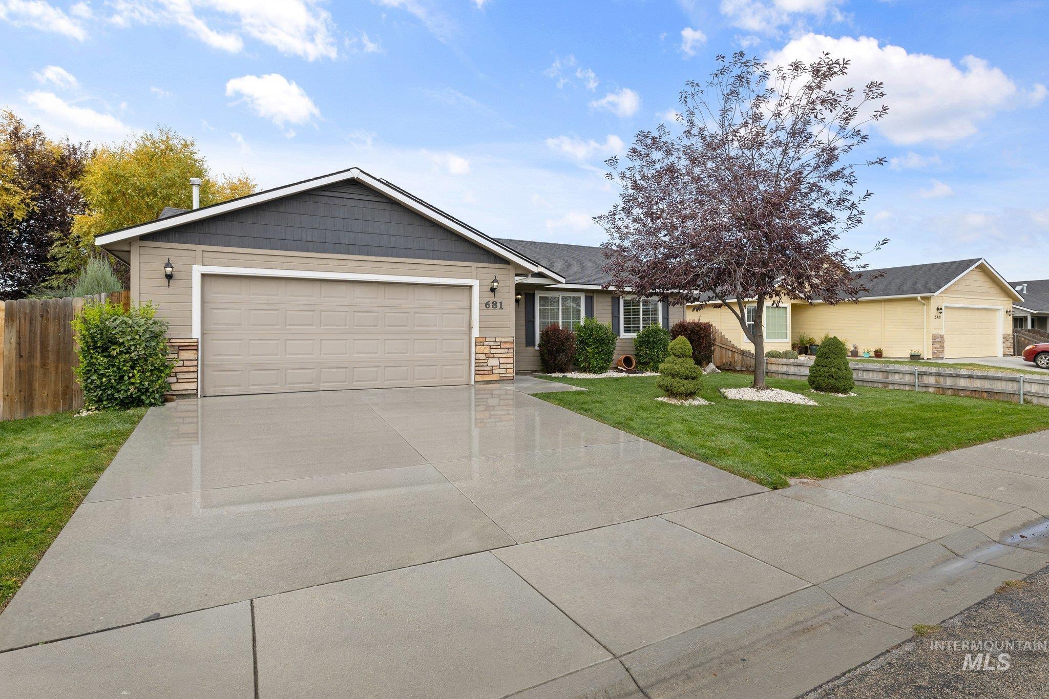 Ranch-style house with a garage, concrete driveway, and stone siding