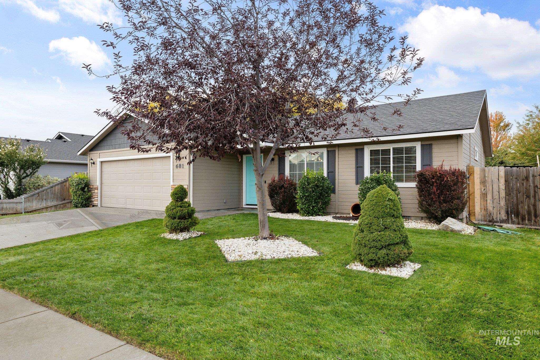 View of front of home with driveway, a shingled roof, and a garage