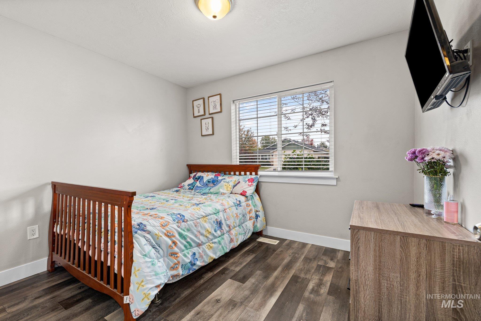 Bedroom featuring baseboards and dark wood-style flooring