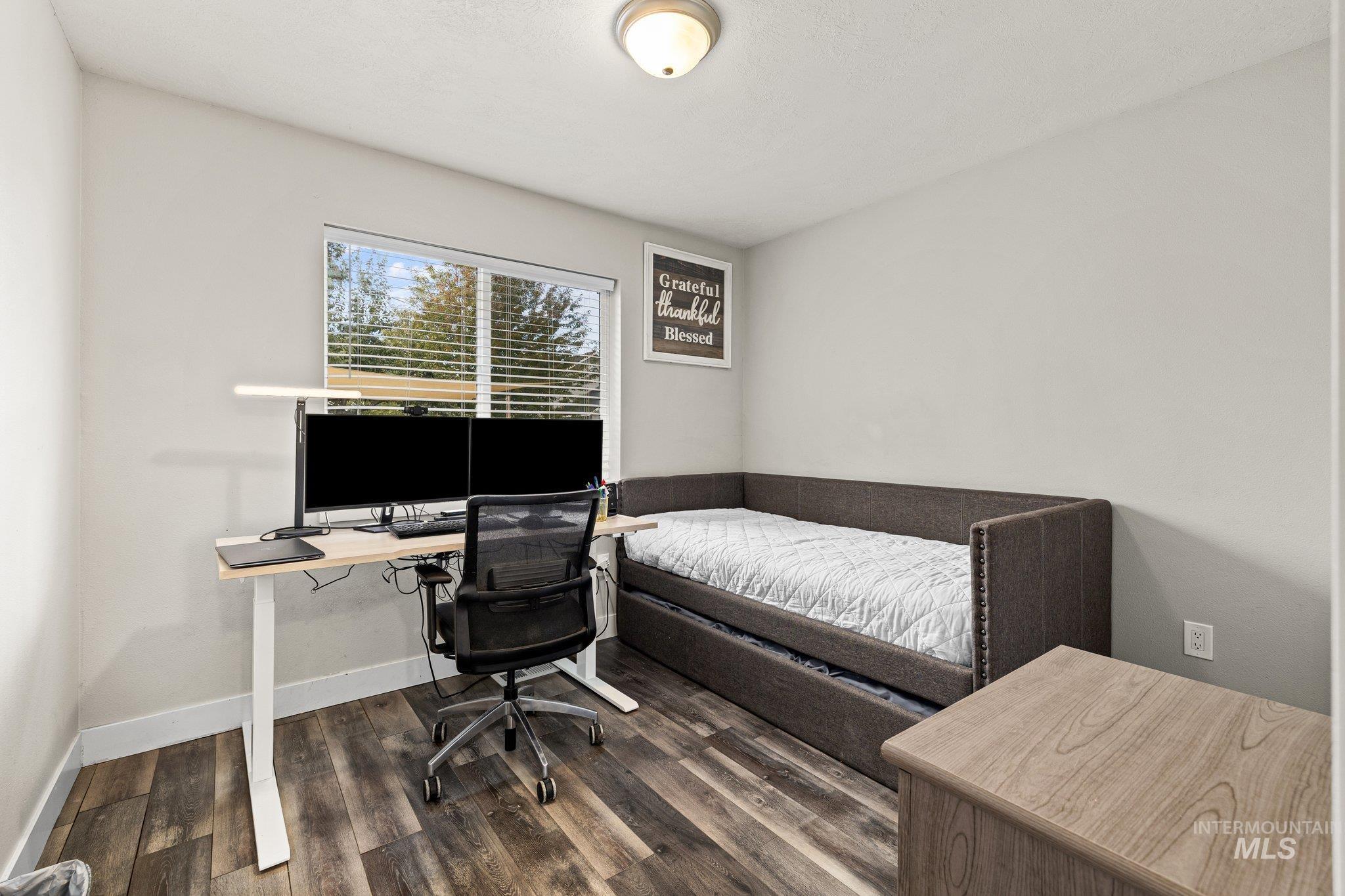 Bedroom featuring dark wood finished floors and a desk