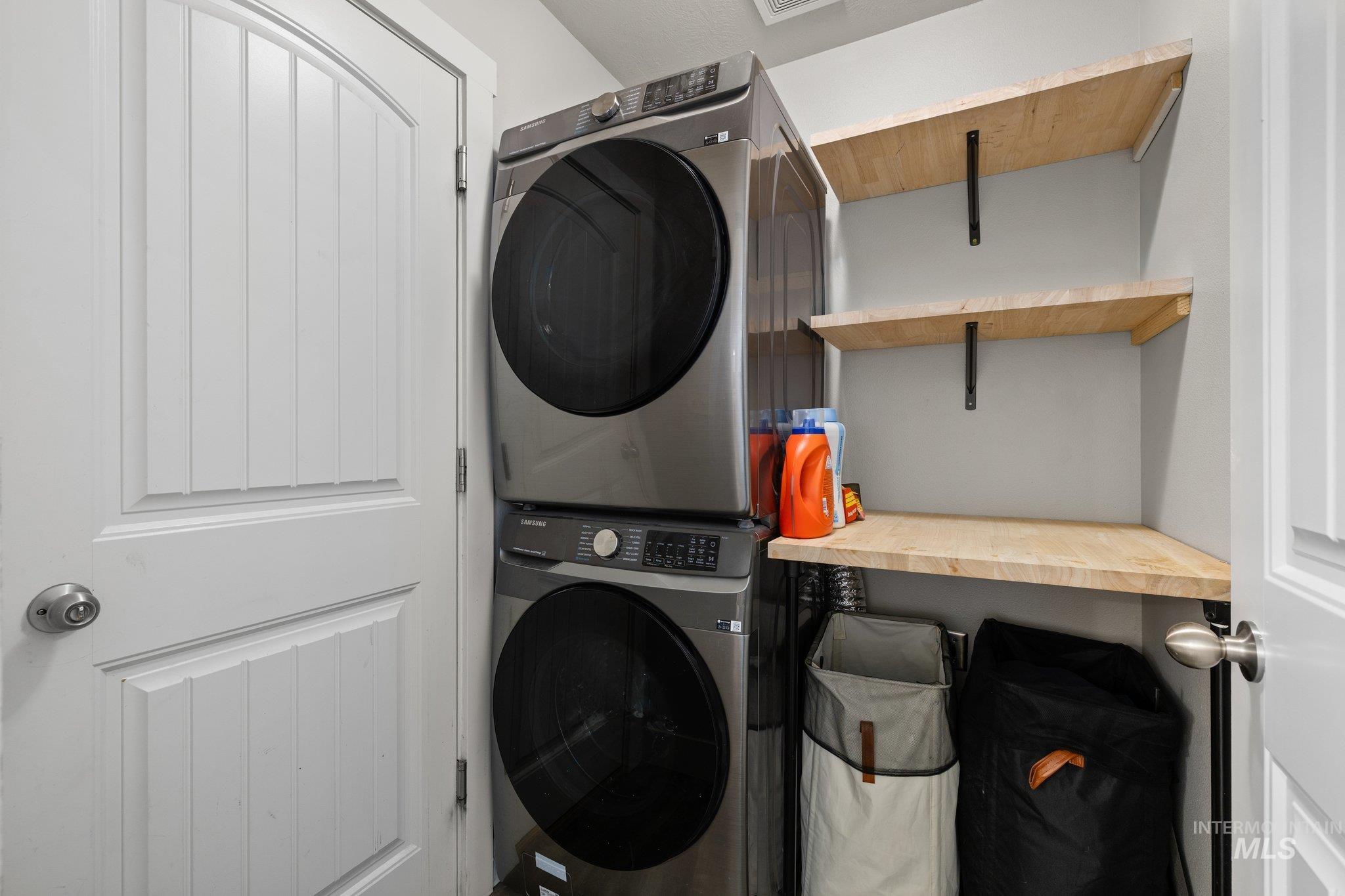 Washroom featuring stacked washer / dryer