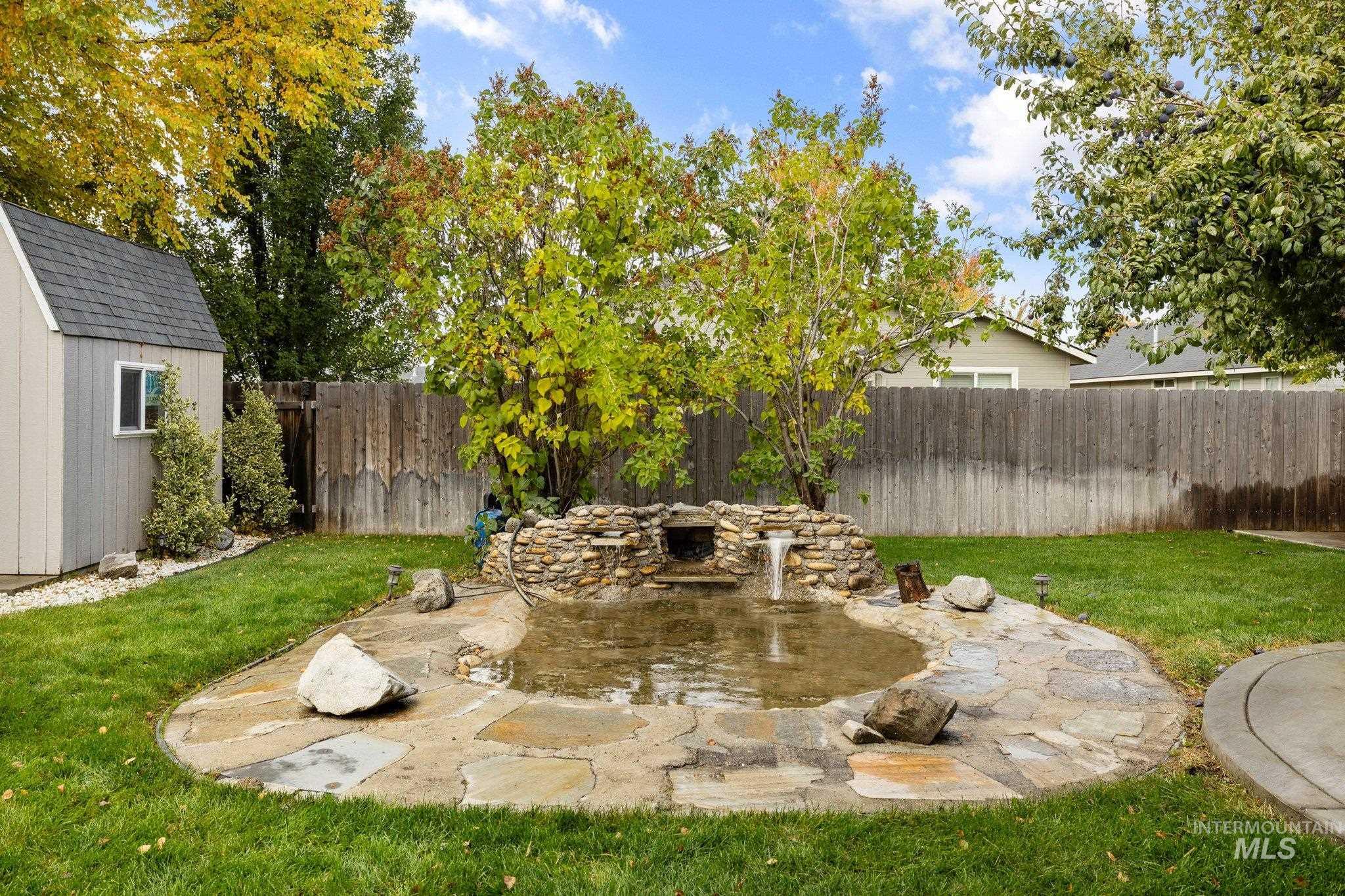 Fenced backyard featuring a patio area and a storage unit