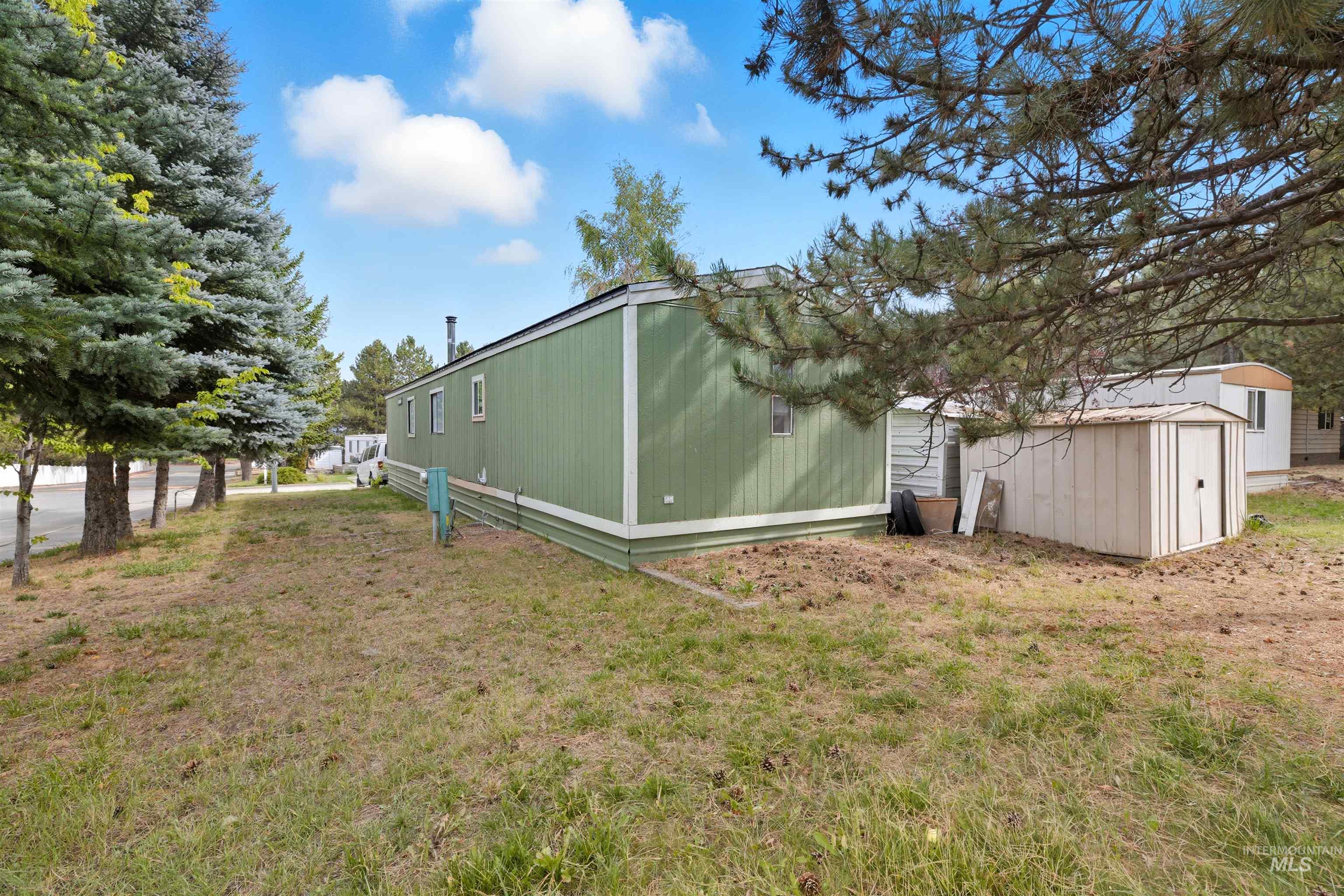 View of grassy yard featuring a storage unit