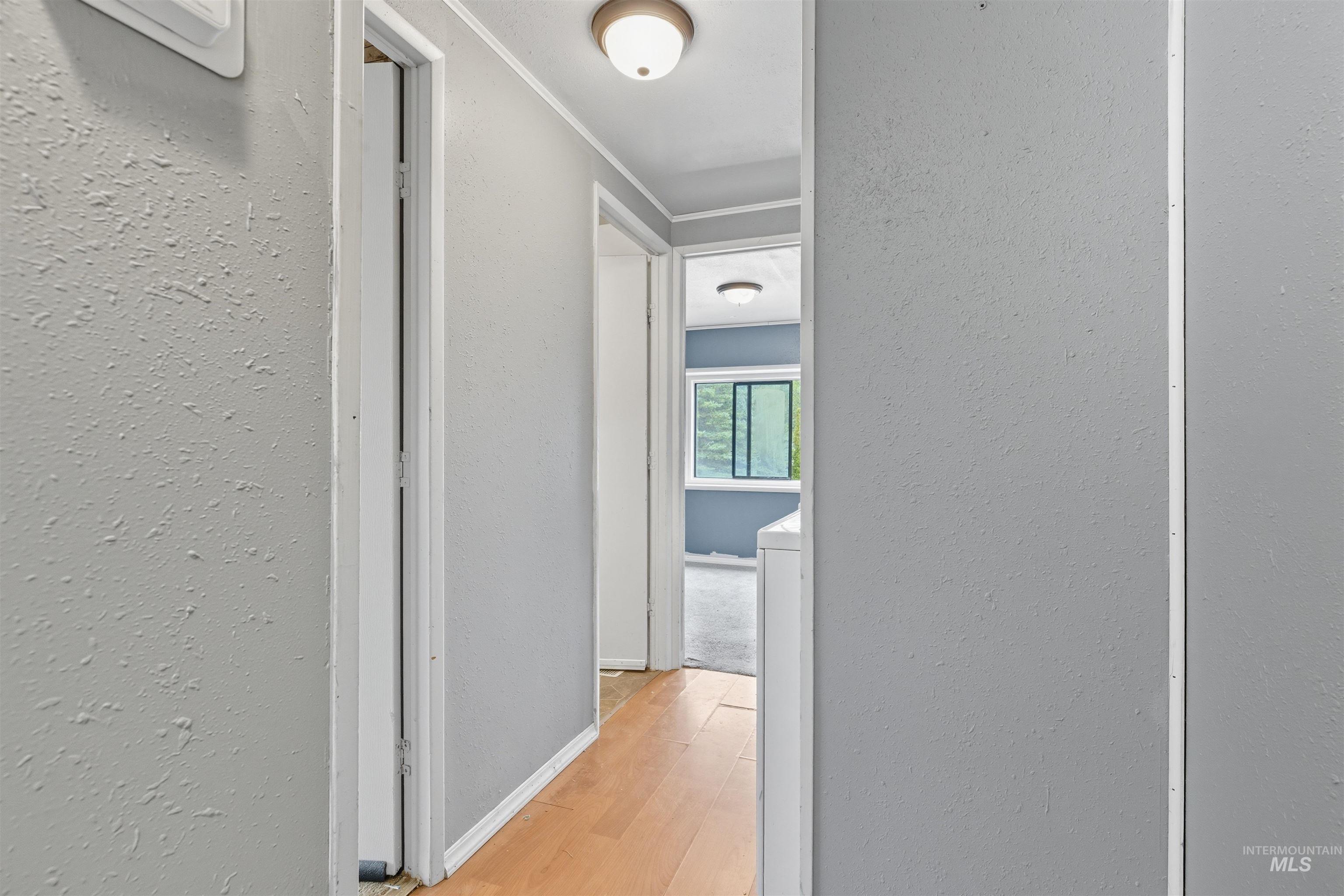 Hall featuring light wood-style floors and a textured wall