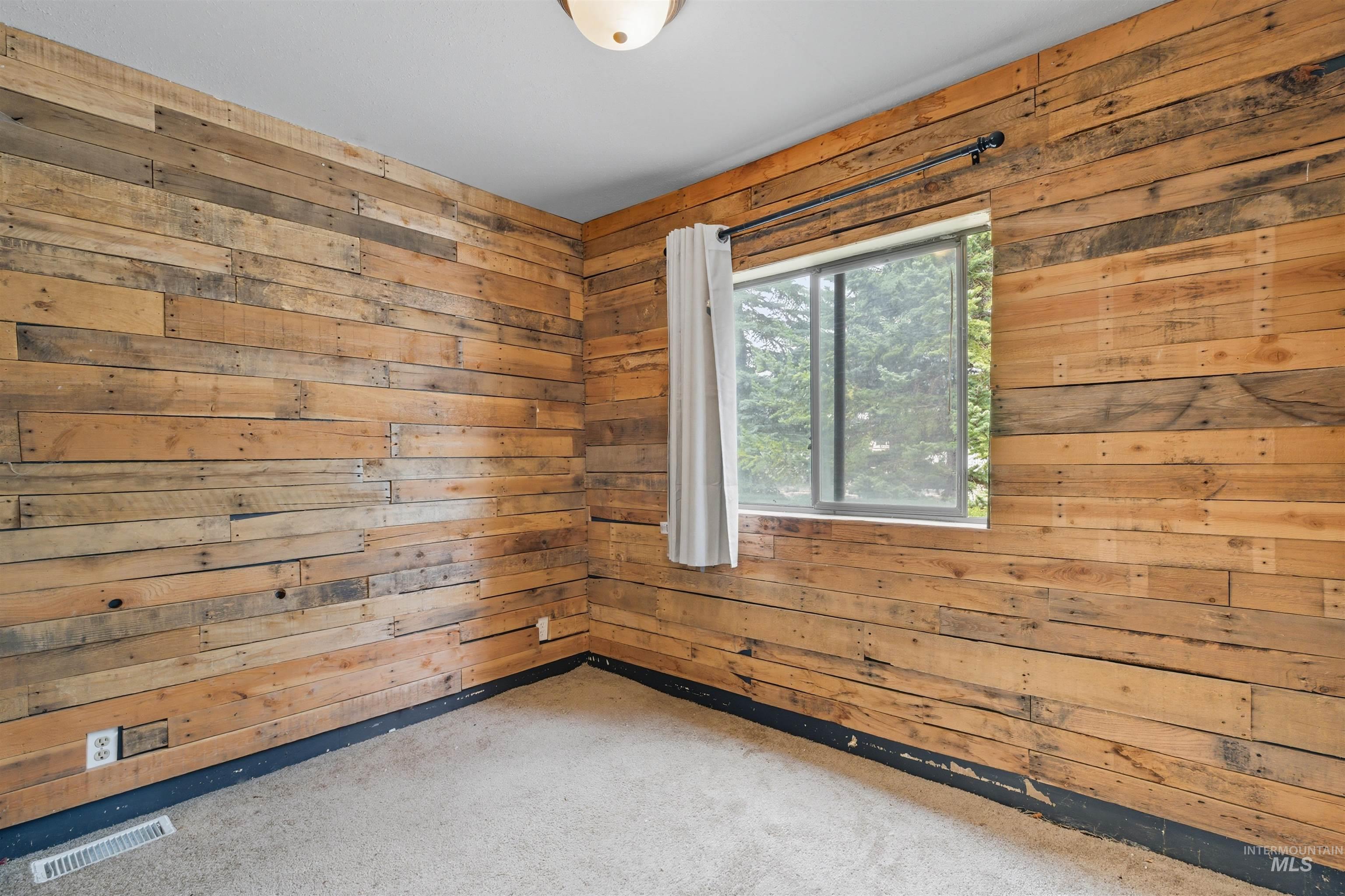 Carpeted empty room with wood walls