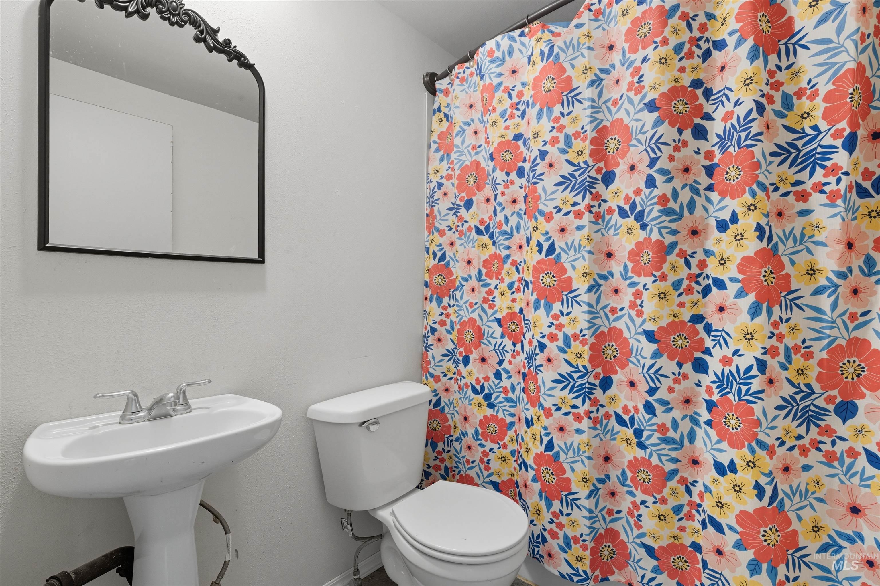 Full bathroom featuring curtained shower and toilet