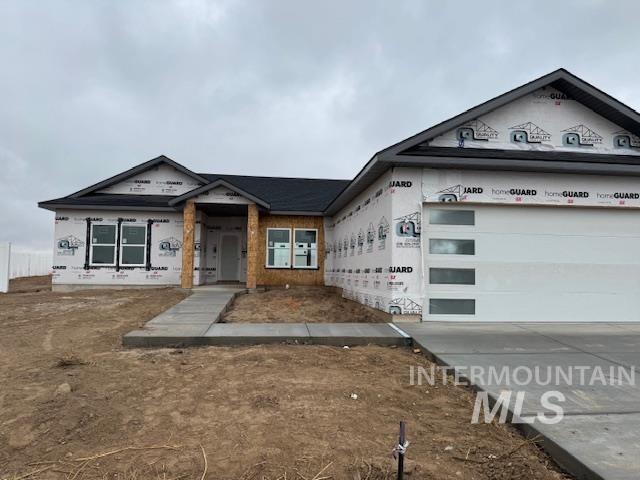 Property under construction with concrete driveway and an attached garage