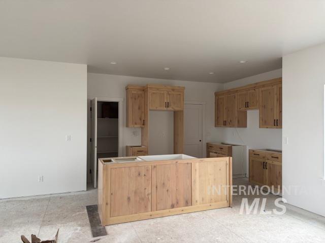 Kitchen featuring a center island and light brown cabinets