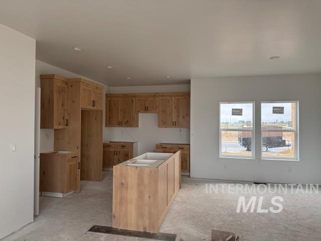 Kitchen featuring a center island, light brown cabinetry, and recessed lighting