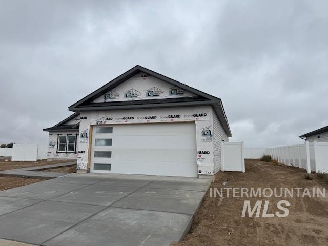 View of front of house with concrete driveway and an attached garage