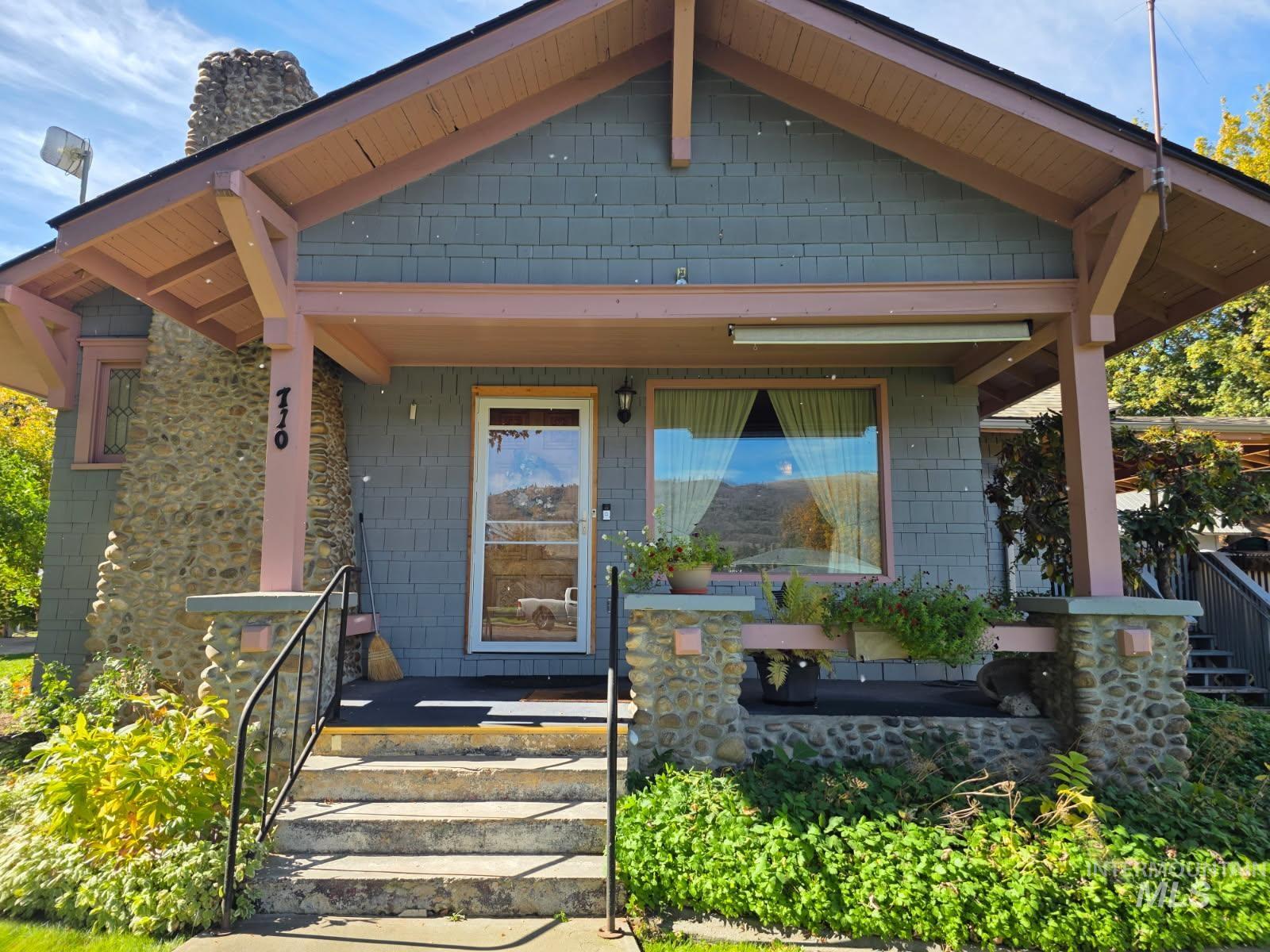 Property entrance with a chimney and a porch
