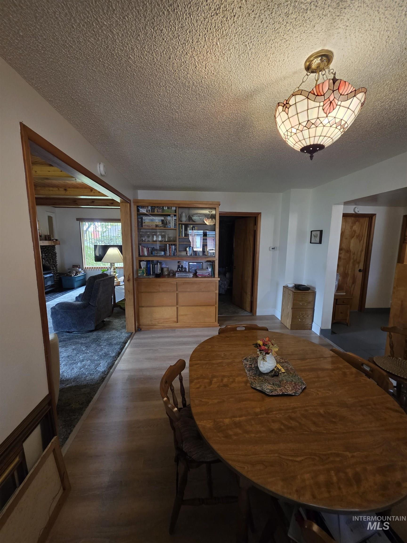 Dining room featuring wood finished floors and a textured ceiling