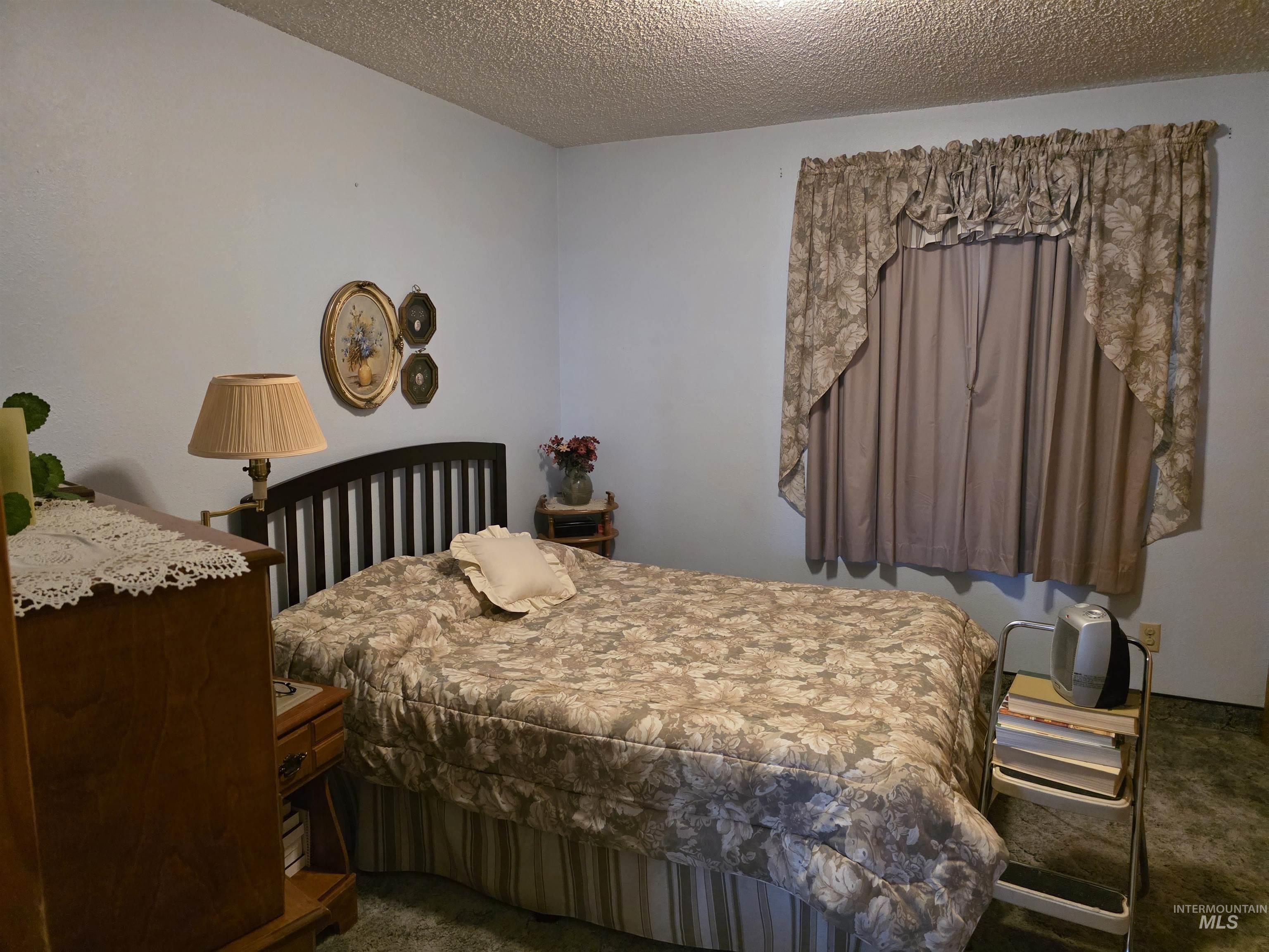 Bedroom with carpet floors and a textured ceiling